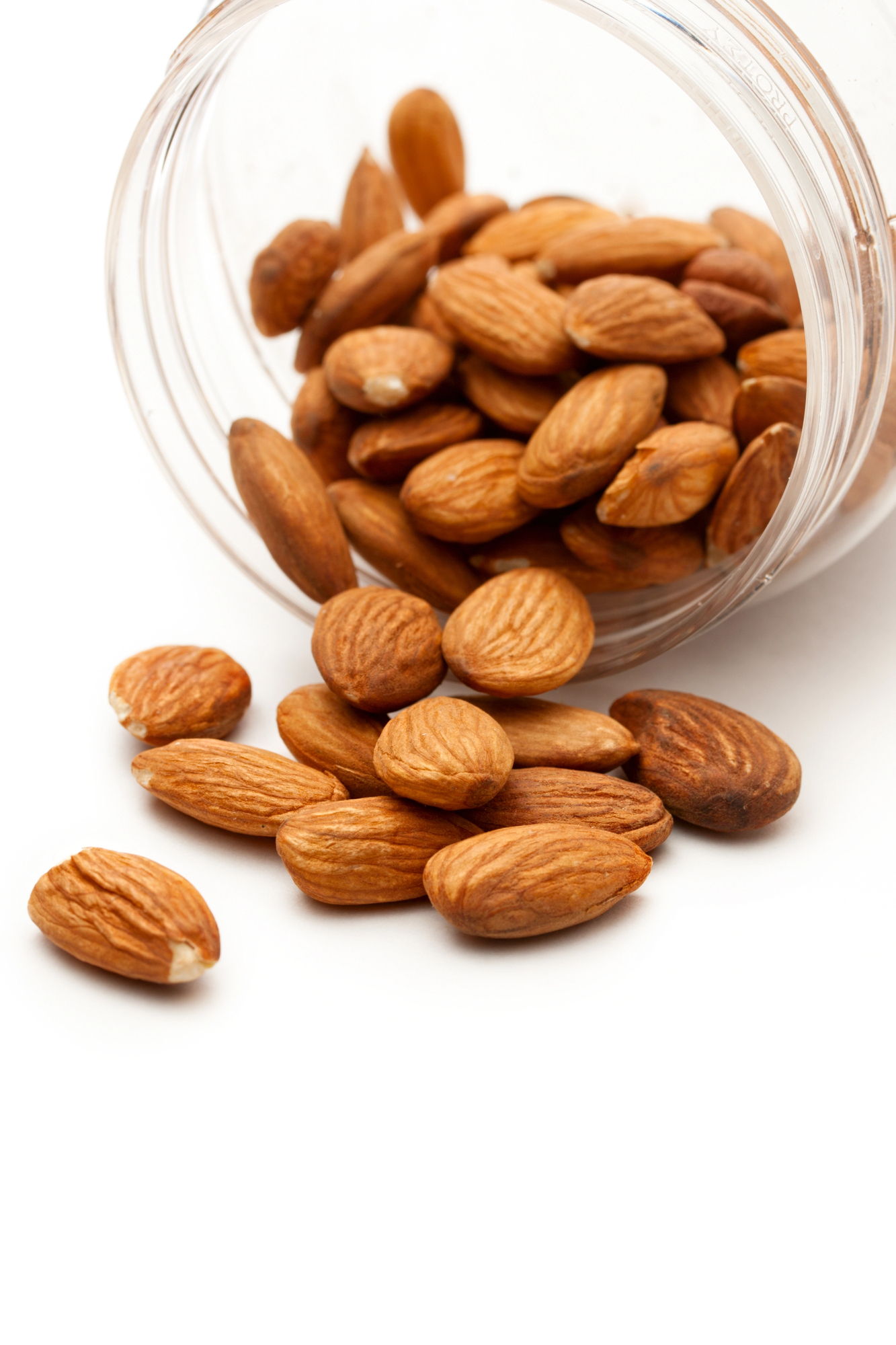 Almonds spilling from a clear glass jar