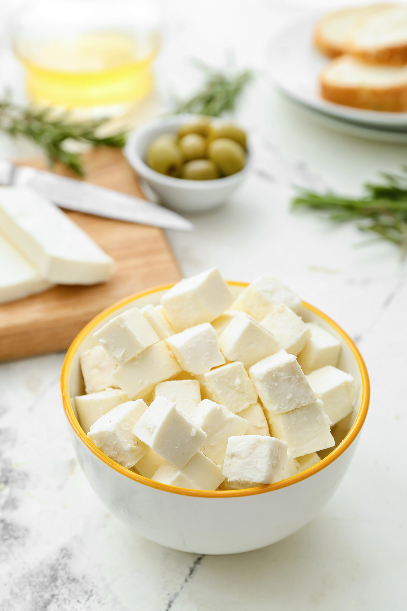 Cubed feta cheese in white bowl with gold rim