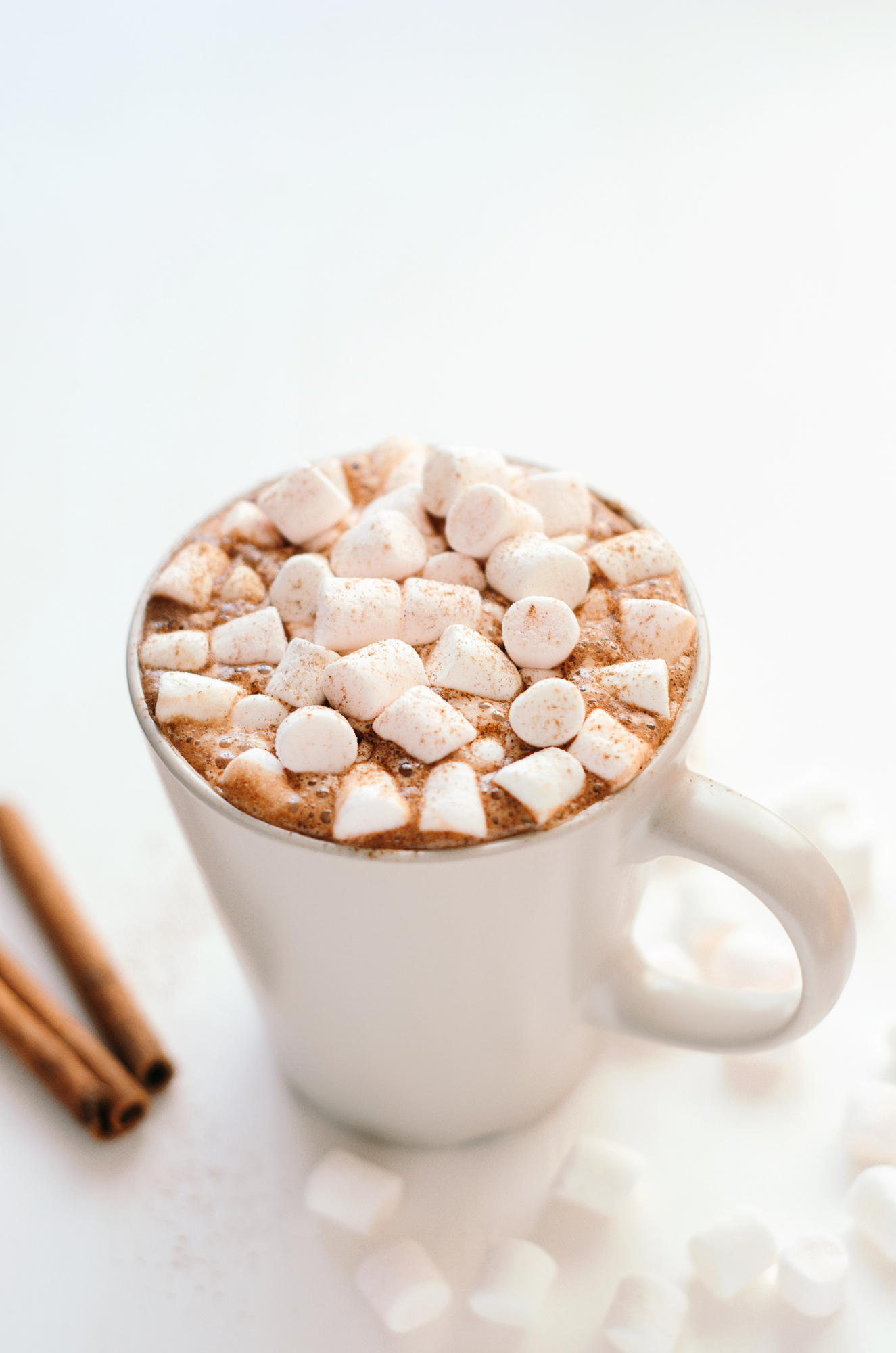 Hot cocoa topped with marshmallows in white mug