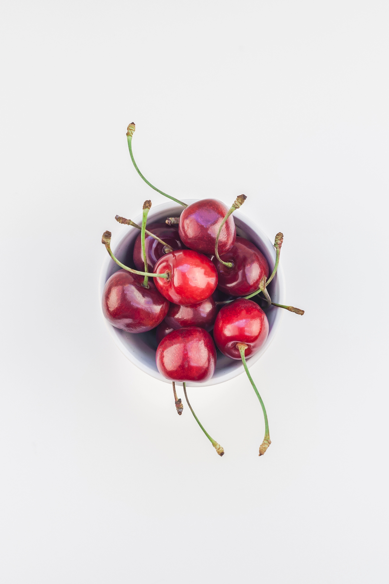 Fresh ripe cherries with stems on white background