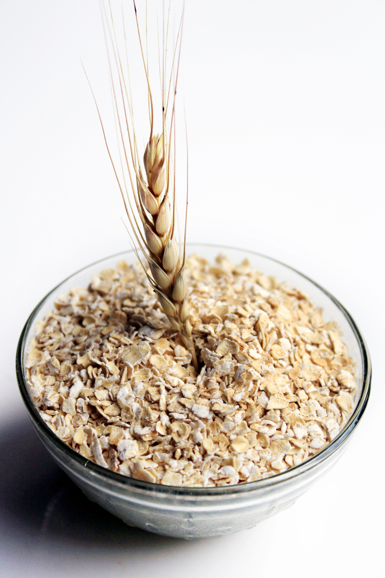 Bowl of oat flakes with wheat stalk