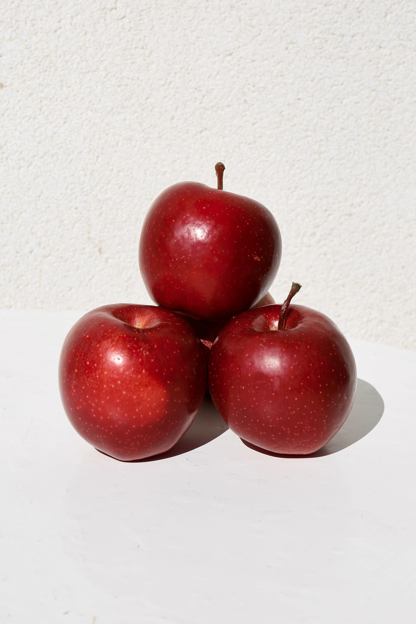 Three red apples stacked in a pyramid