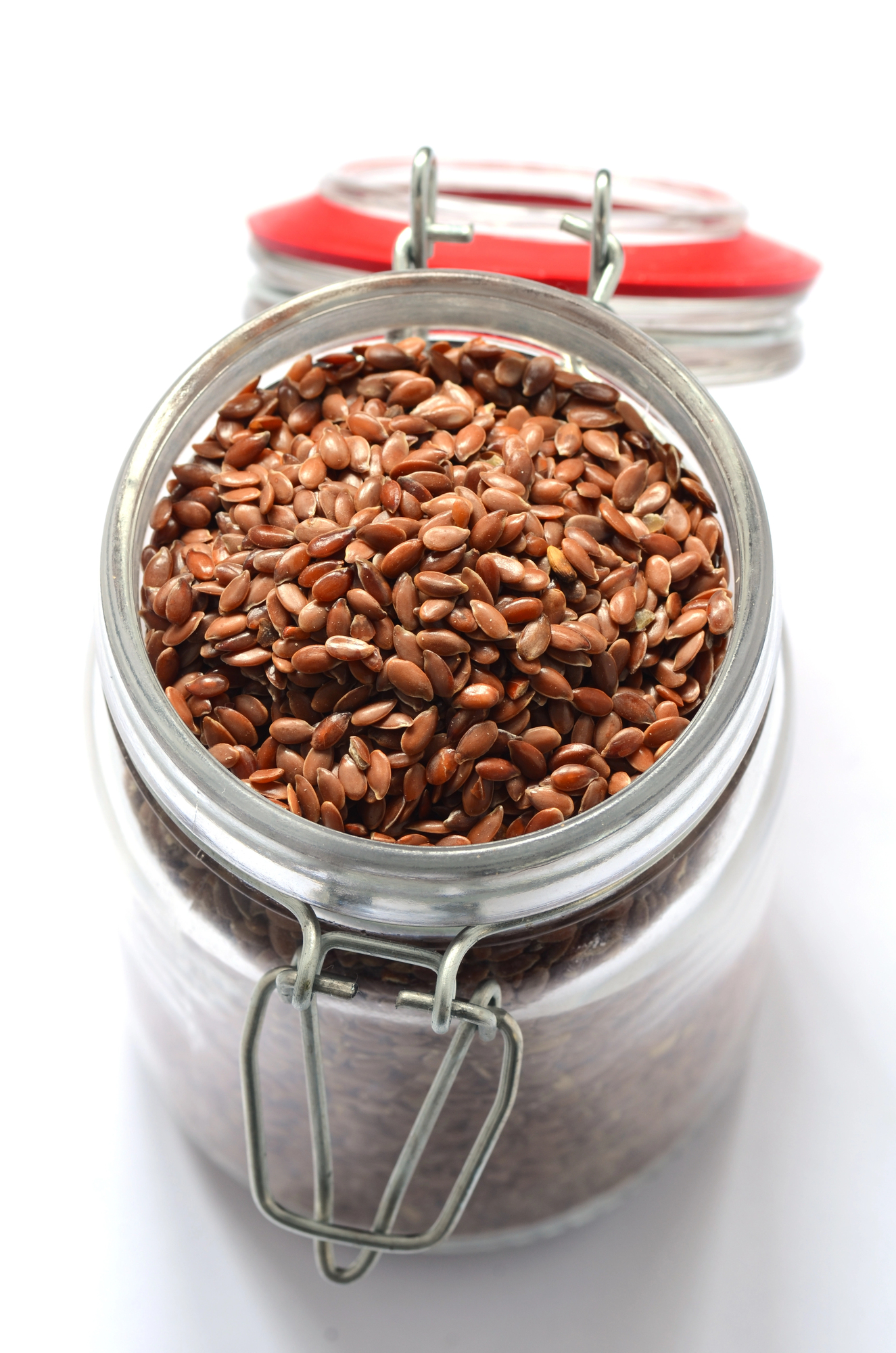 Open glass jar filled with brown flax seeds