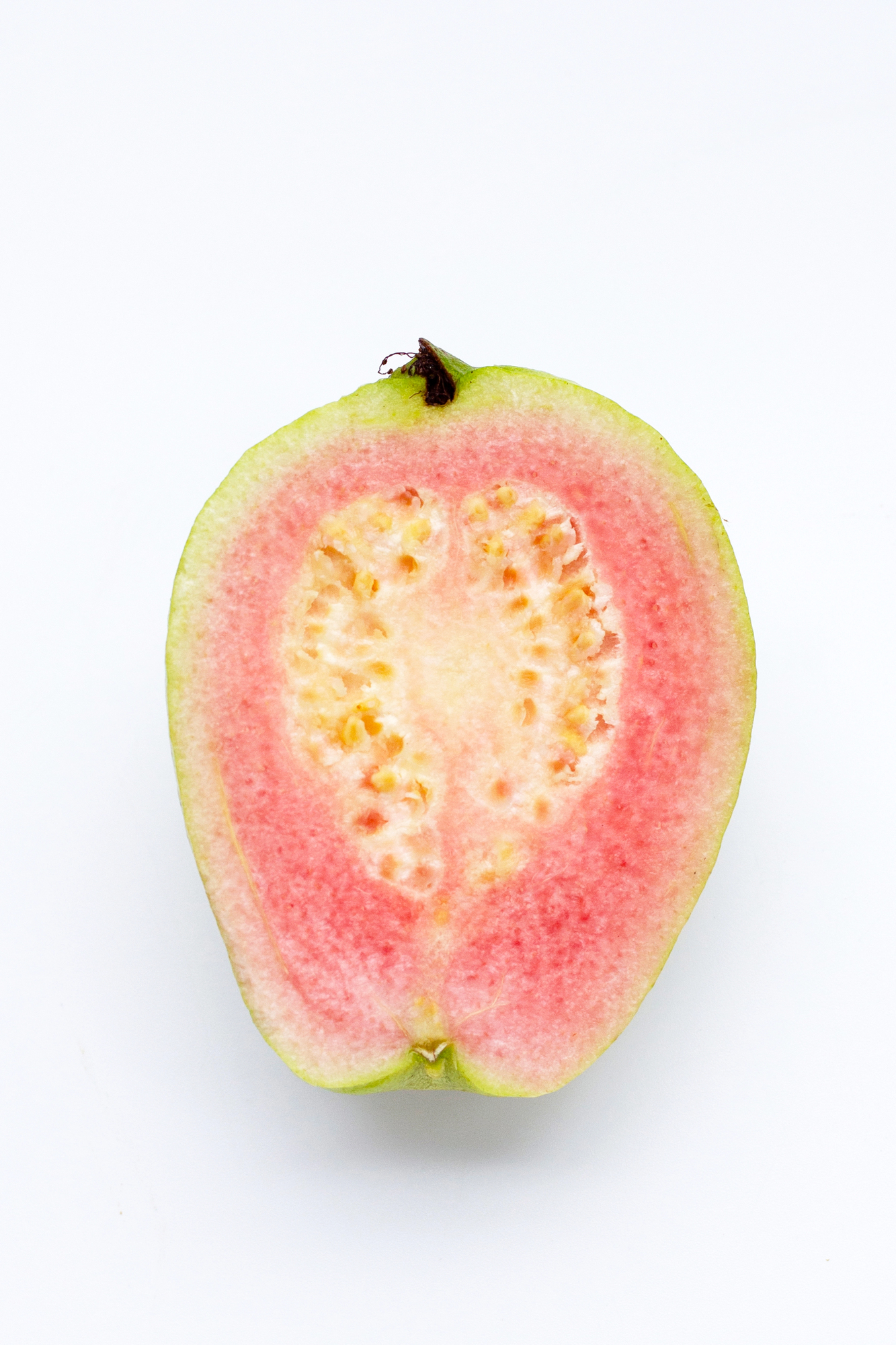 Pink guava halved showing seeds and flesh