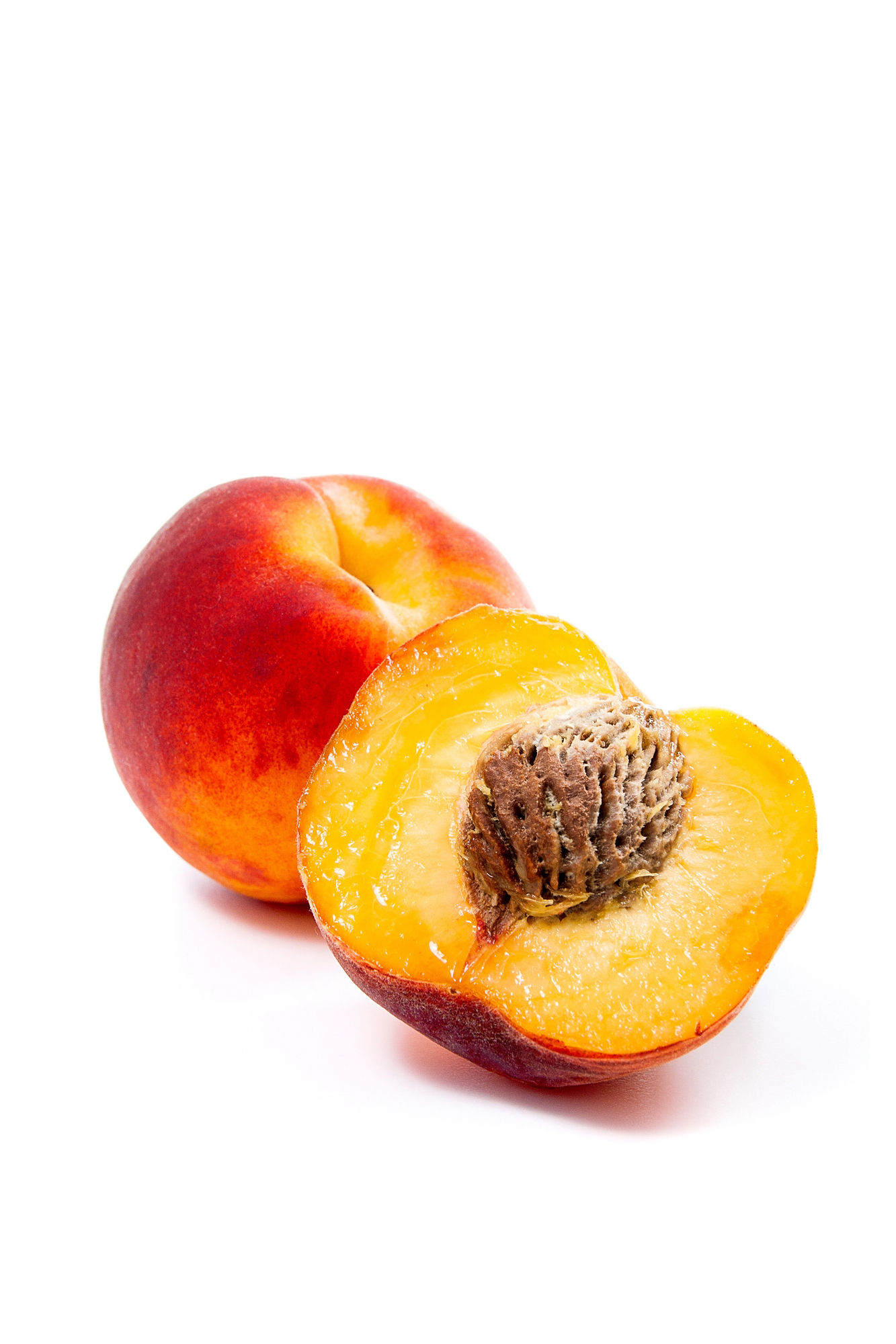 Whole peach and peach halves with pit exposed