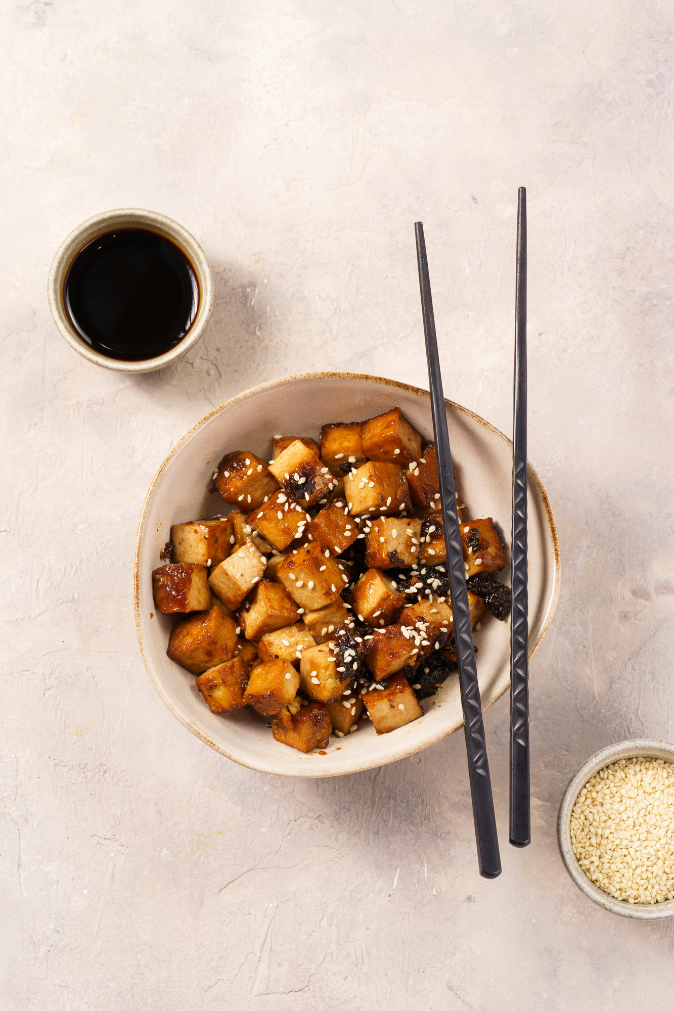 Sticky tofu with sesame seeds in white bowl