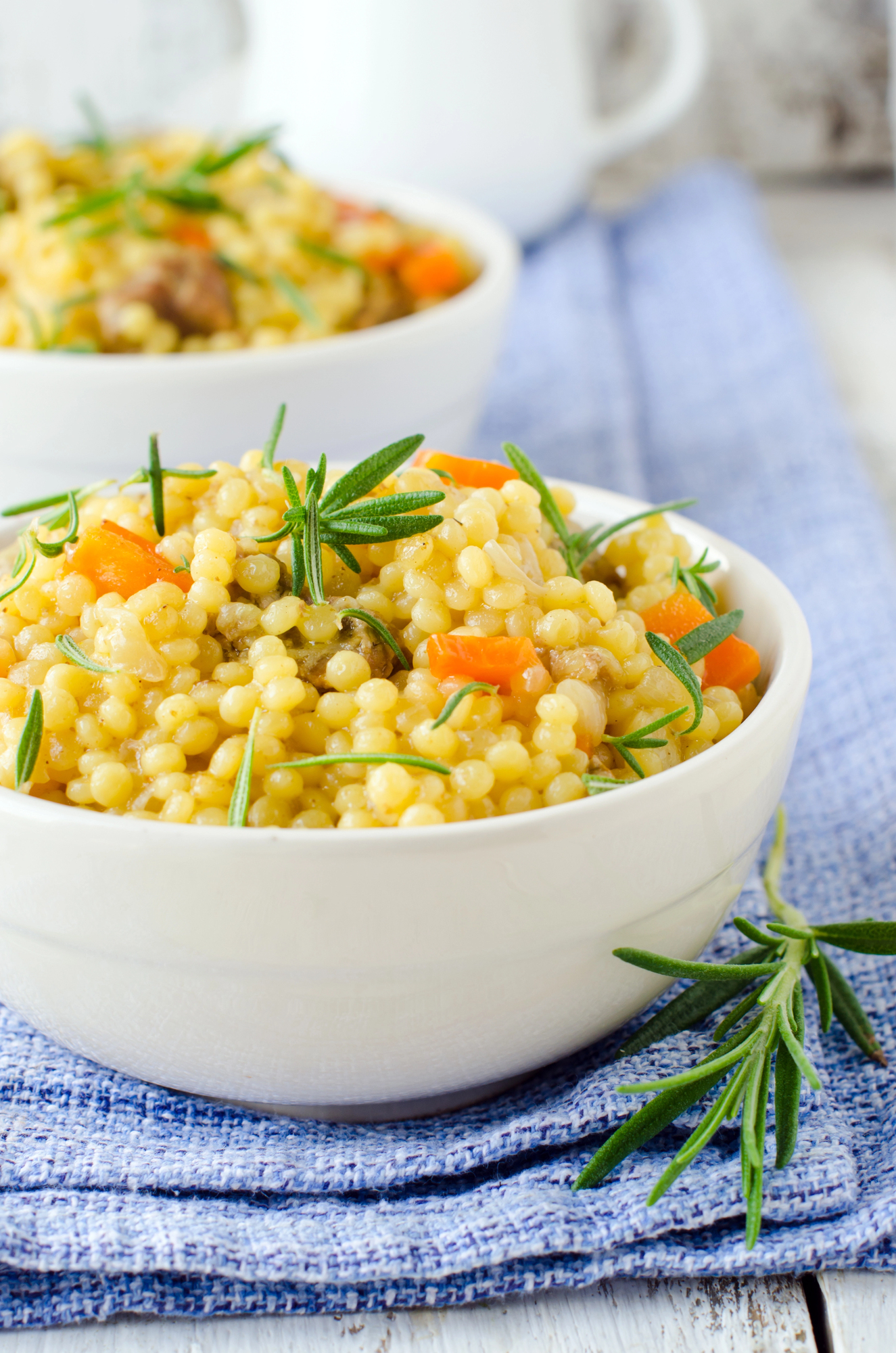 Couscous with pumpkin and peas in white bowl