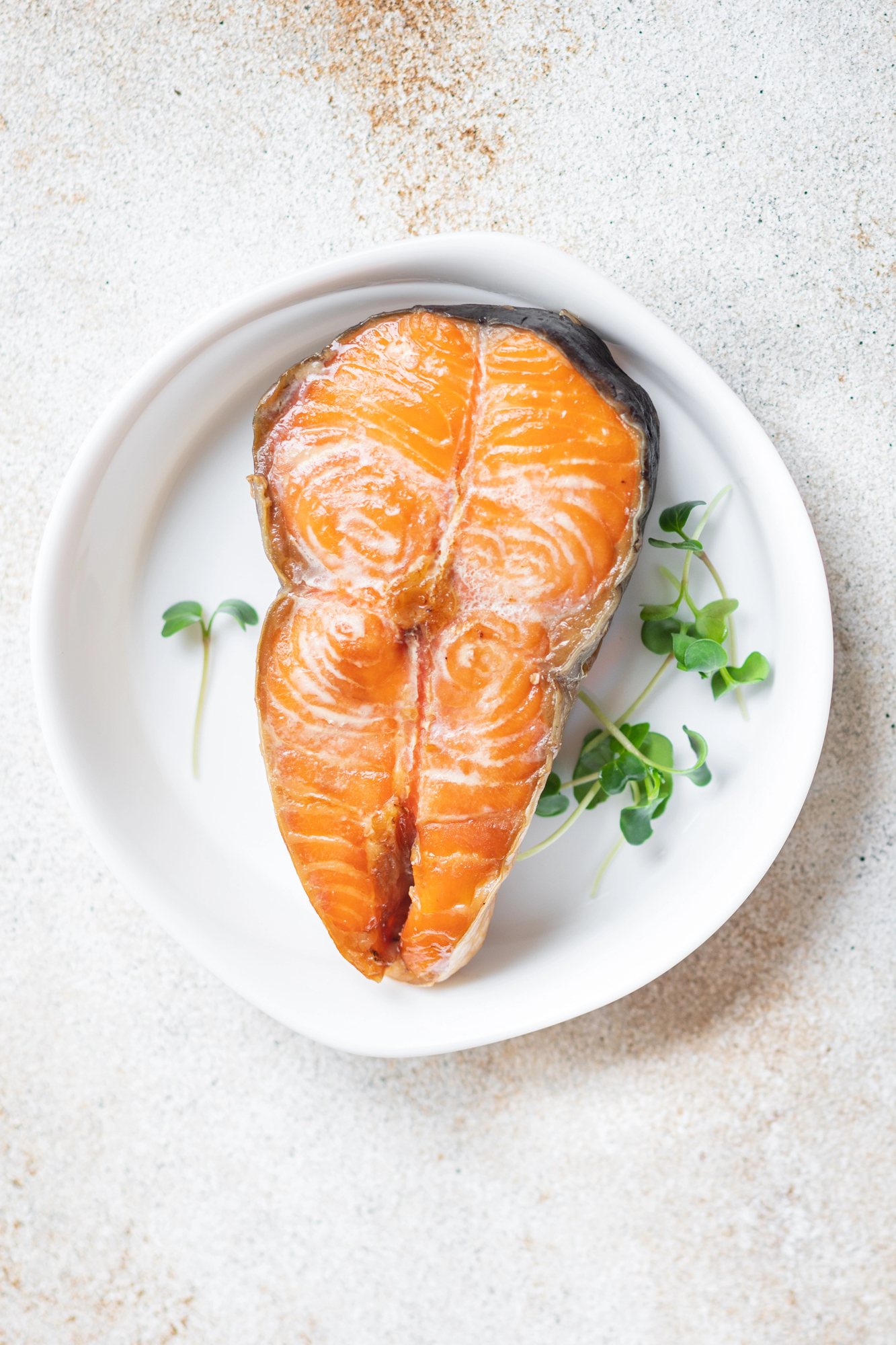 Cooked salmon steak on white plate