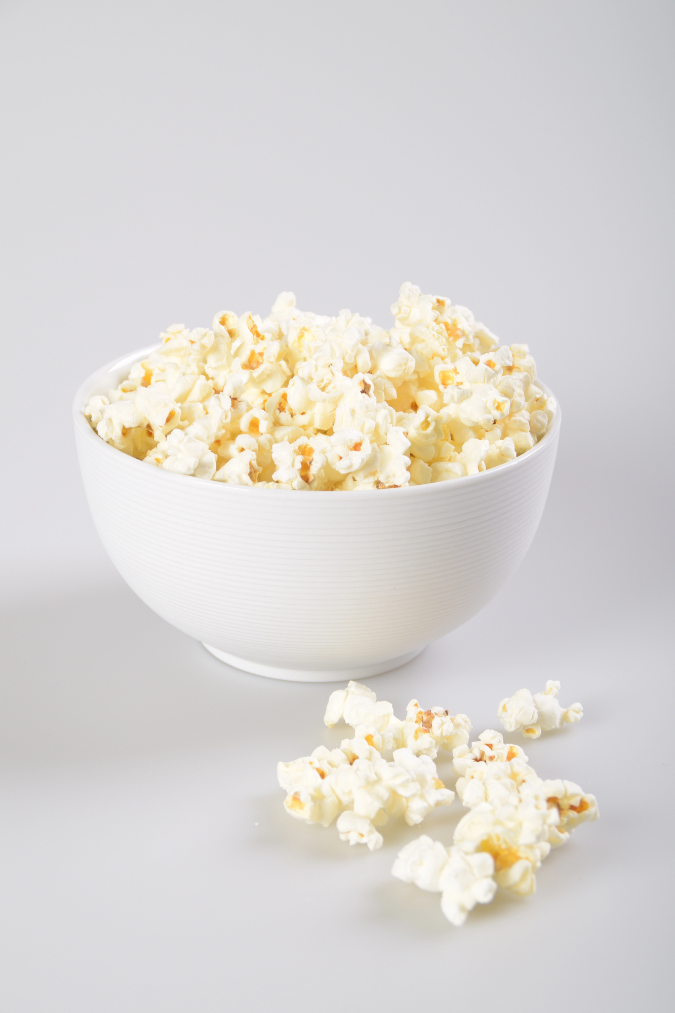 White bowl filled with buttered popcorn