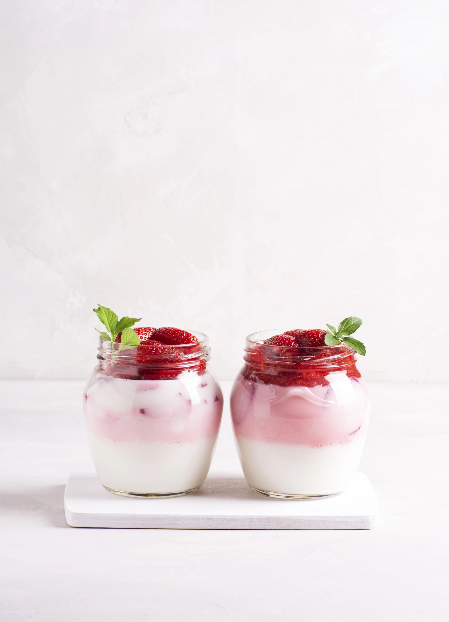 Two yogurt parfaits with strawberries and mint