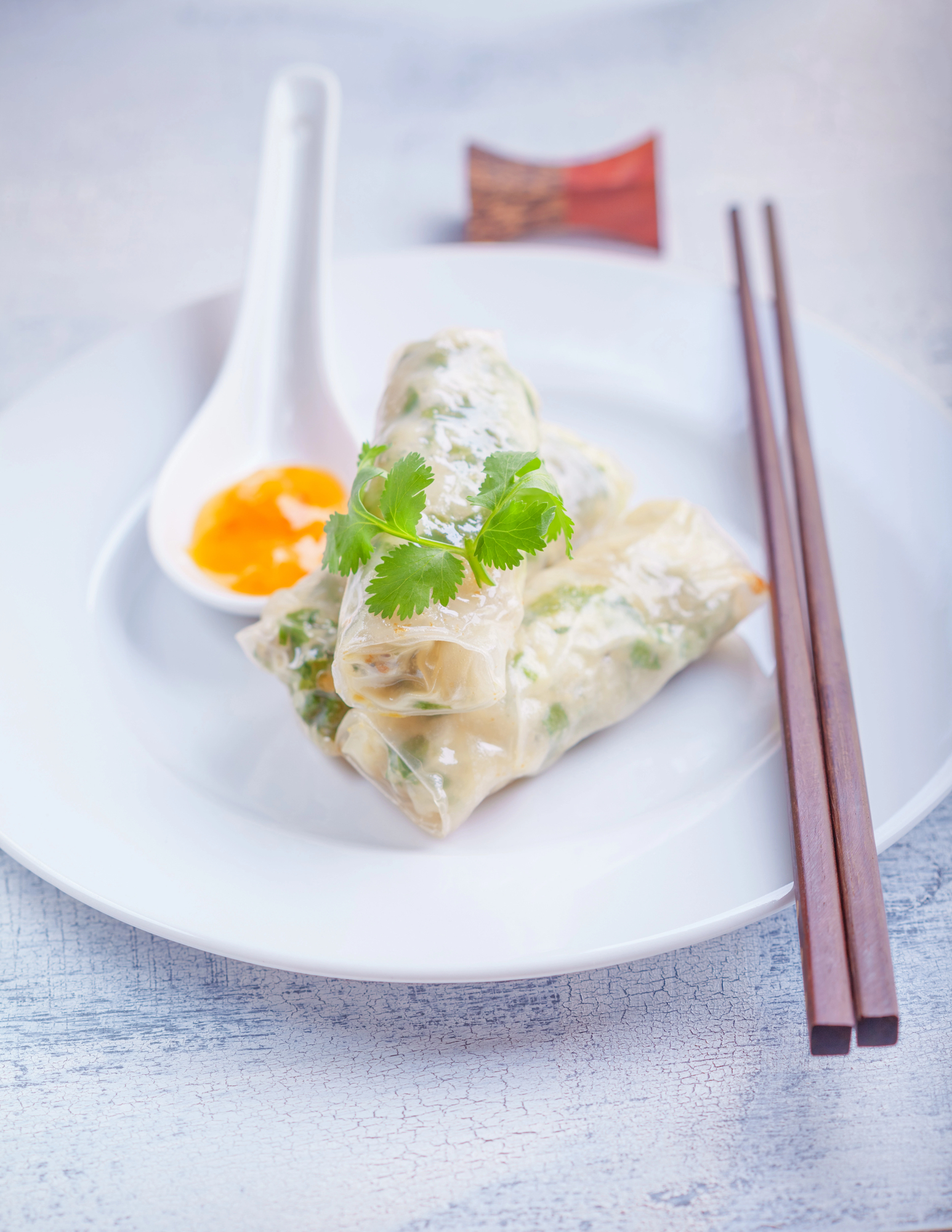 Rice paper rolls with shrimp and herbs on white plate