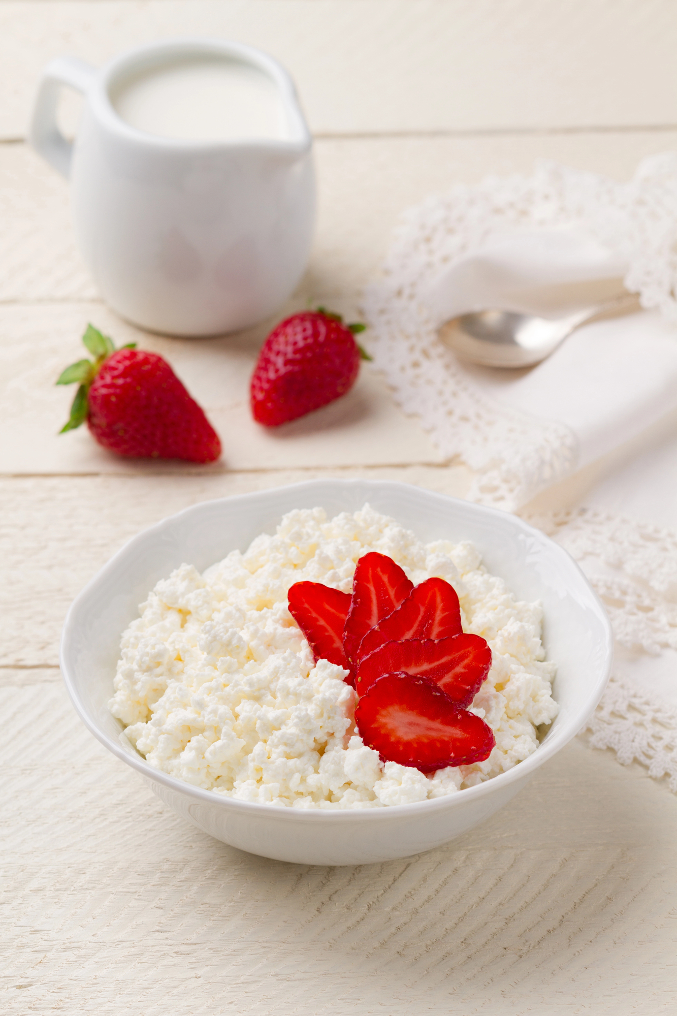 Bowl of cottage cheese topped with fresh red strawberries