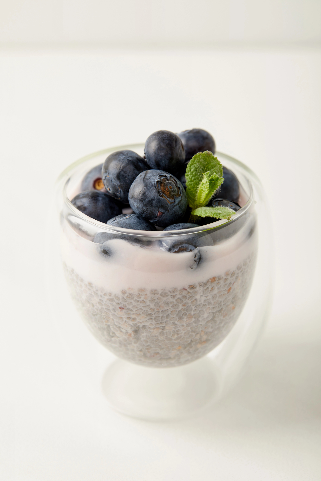 Chia seed pudding topped with blueberries and mint leaf