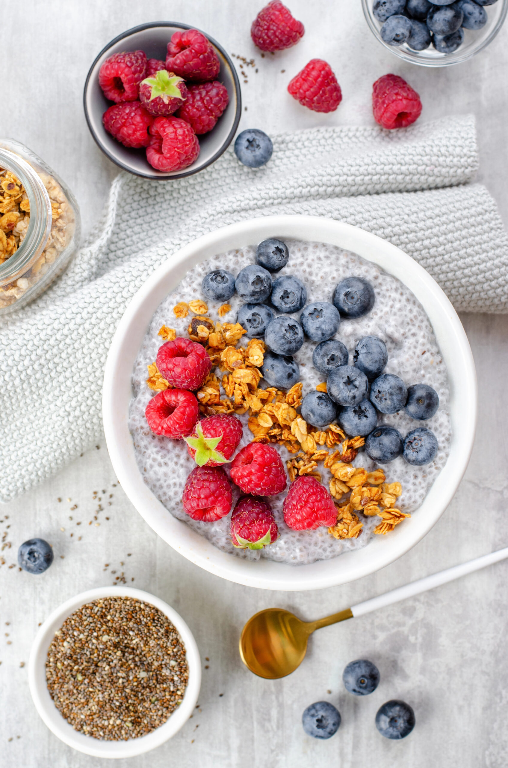 Chia pudding bowls topped with raspberries blueberries and granola