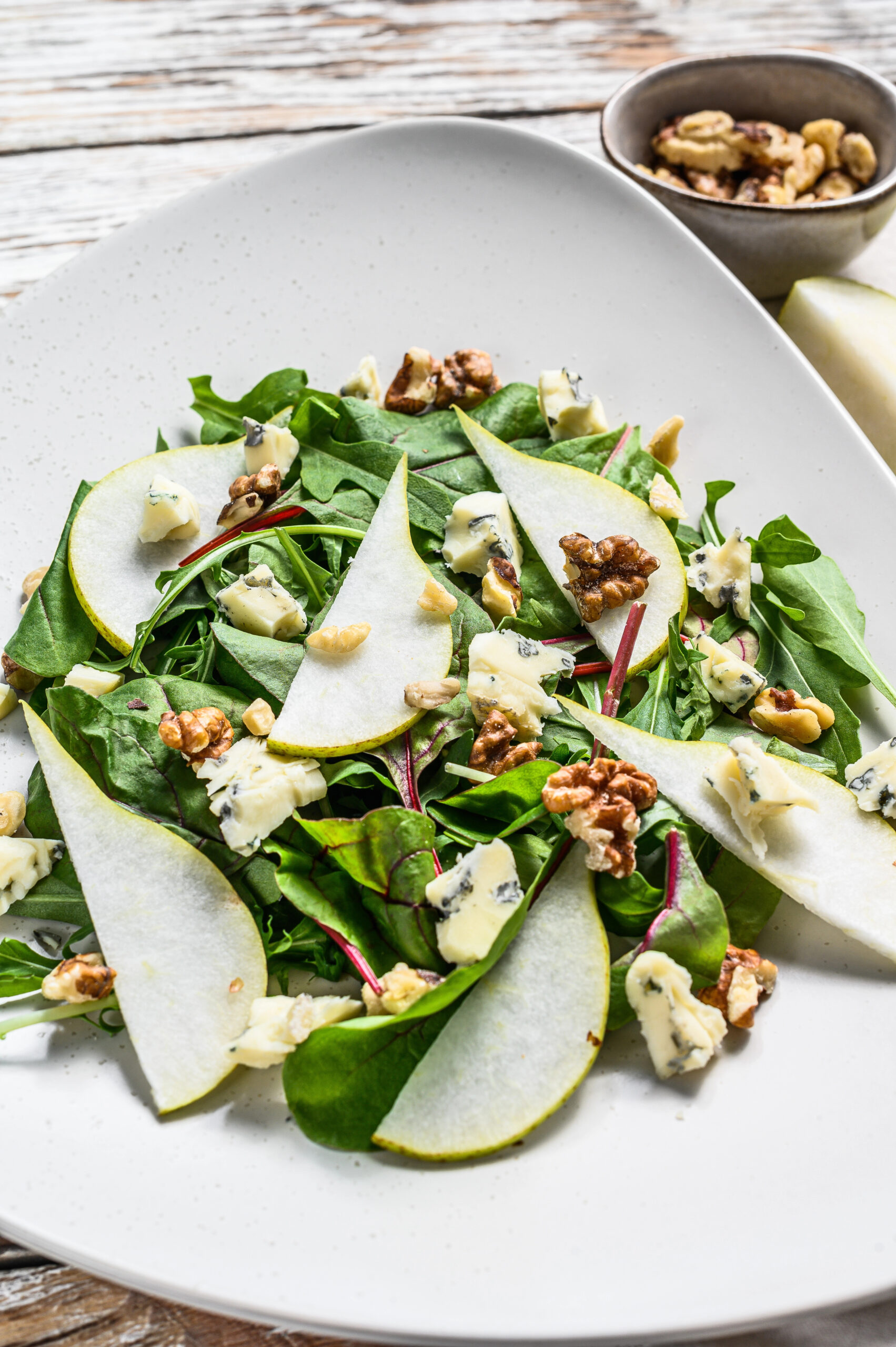 Green salad with pear slices walnuts and blue cheese