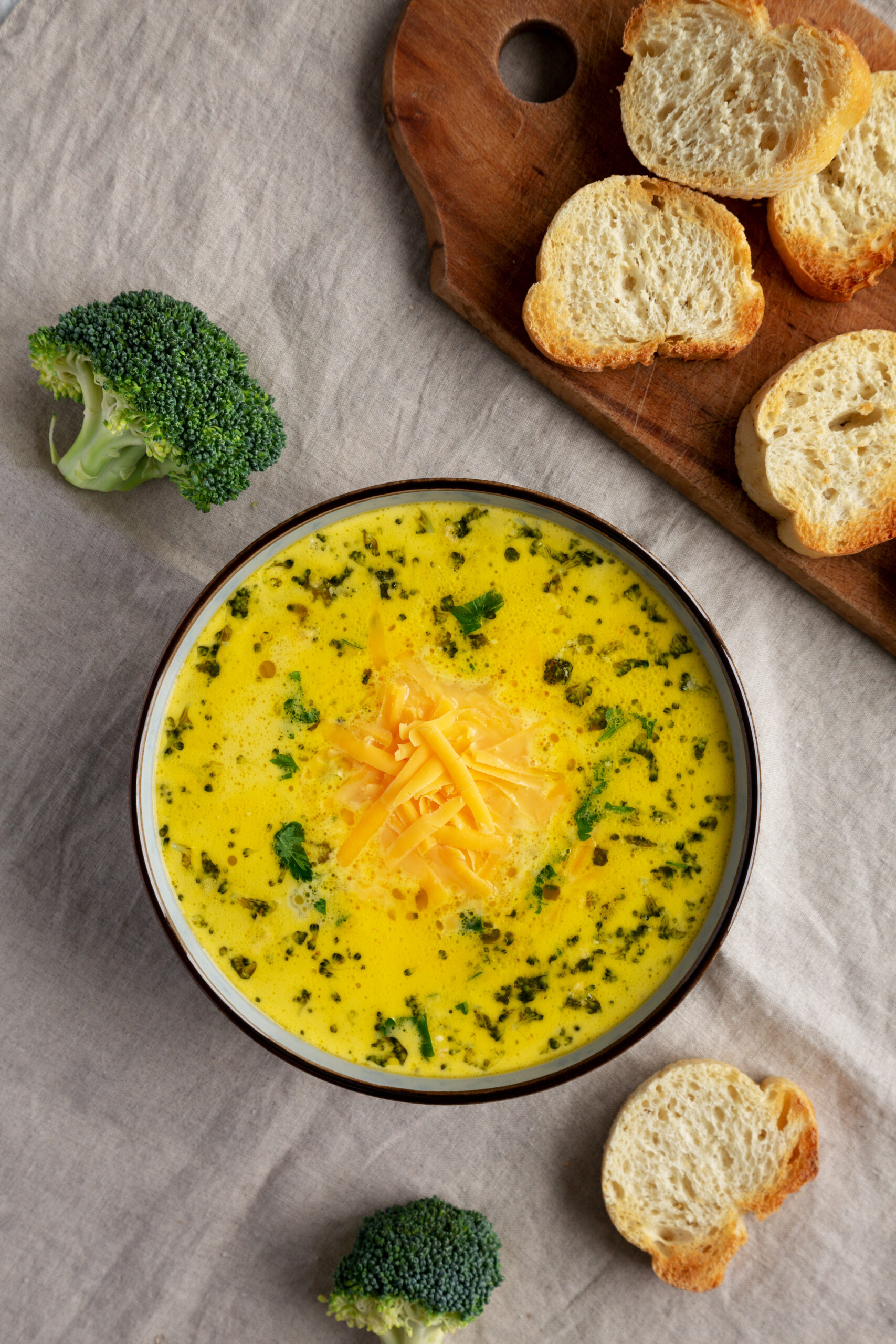 Broccoli cheddar soup garnished with herbs and shredded cheese