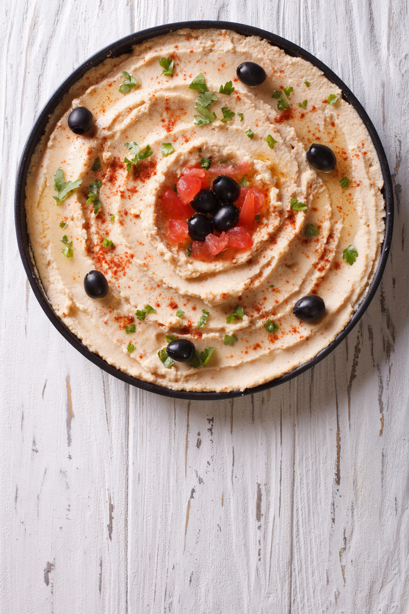 Hummus topped with olives and red pepper