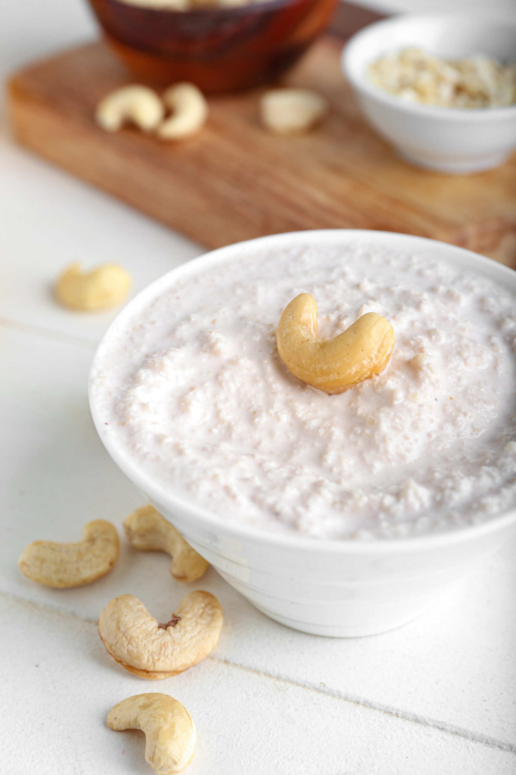 Cashew sour cream in white bowl with cashew nut on top