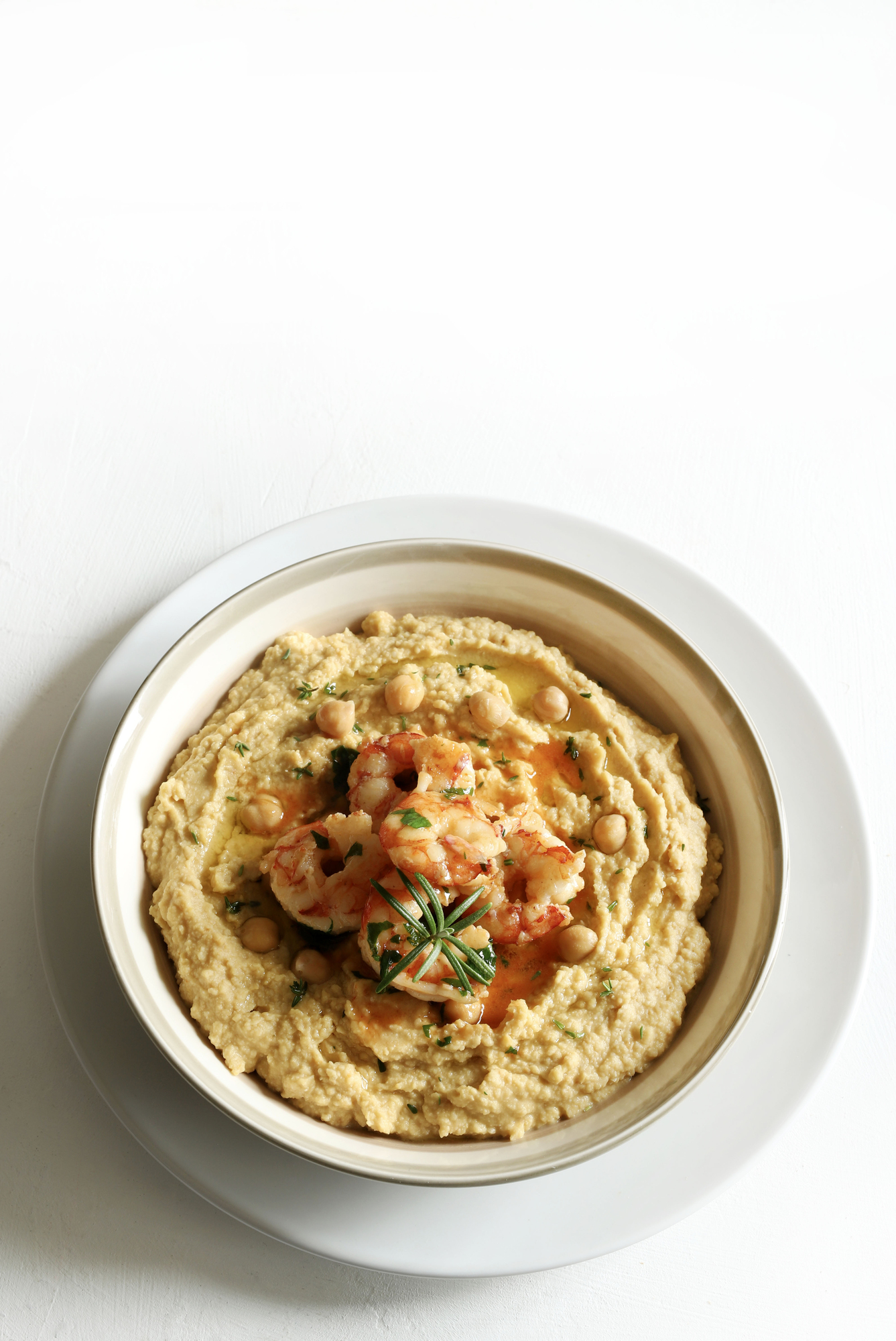 Hummus topped with cooked shrimp and herbs