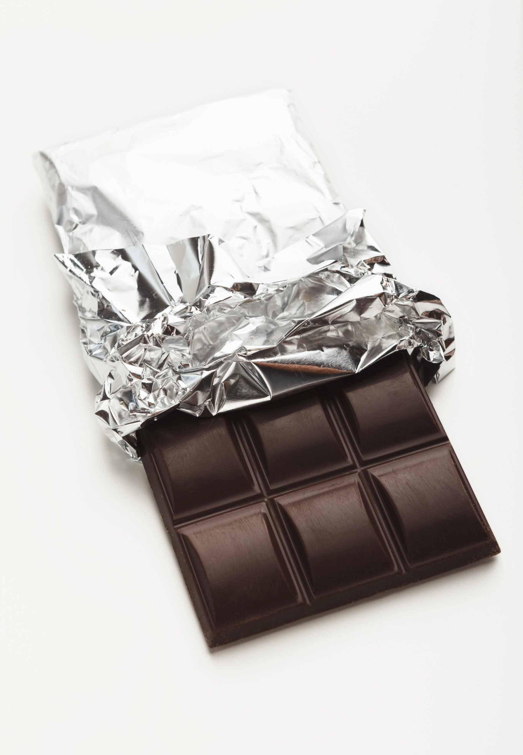 Dark chocolate bar with opened silver wrapper