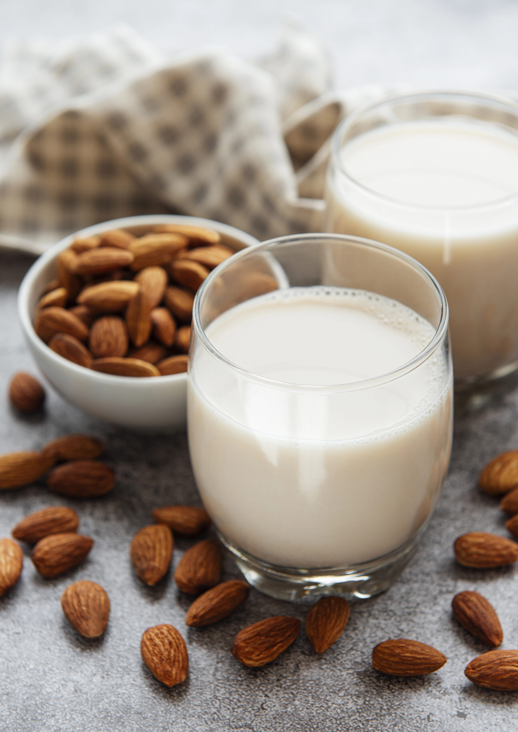 Two glasses of almond milk with whole almonds