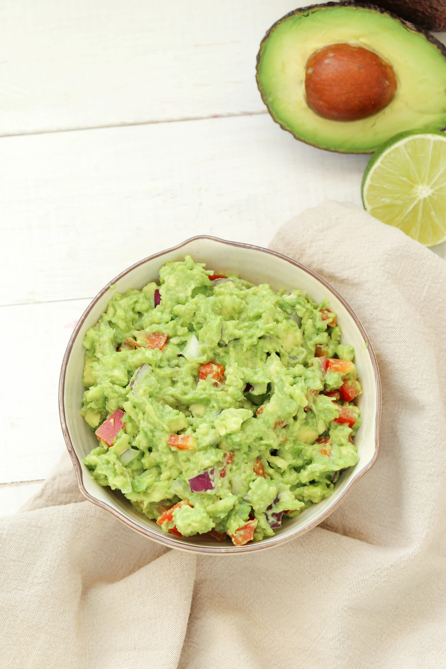 Bowl of guacamole with mixed vegetables and avocado