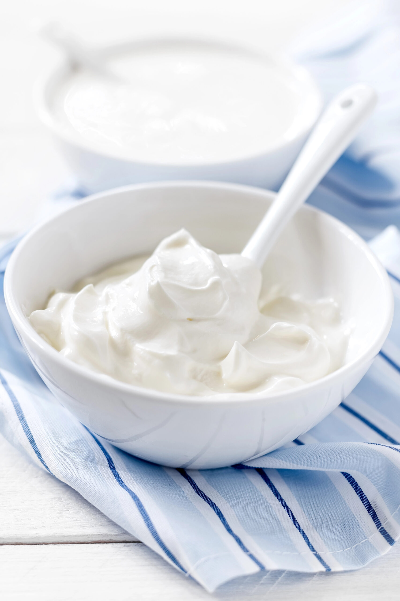 White bowl of sour cream with spoon