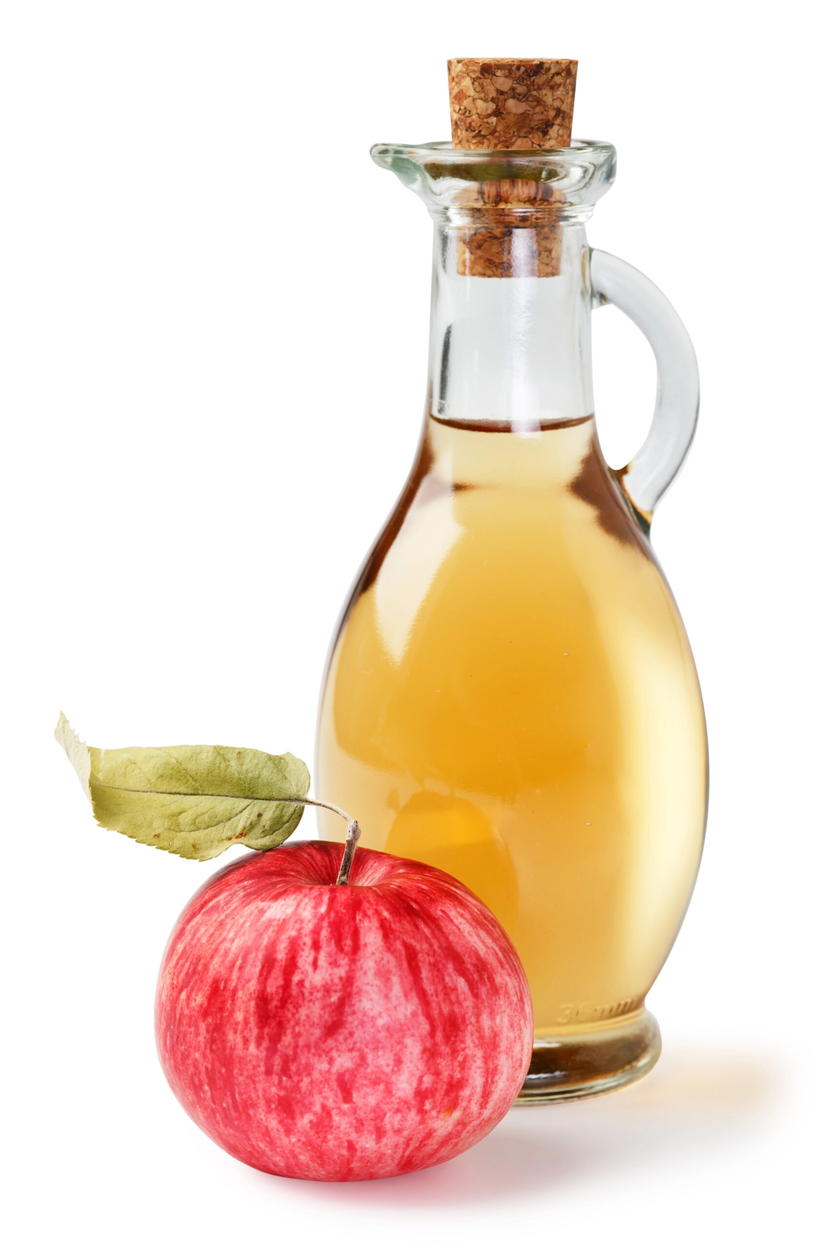Whole red apple next to bottle of golden apple cider vinegar