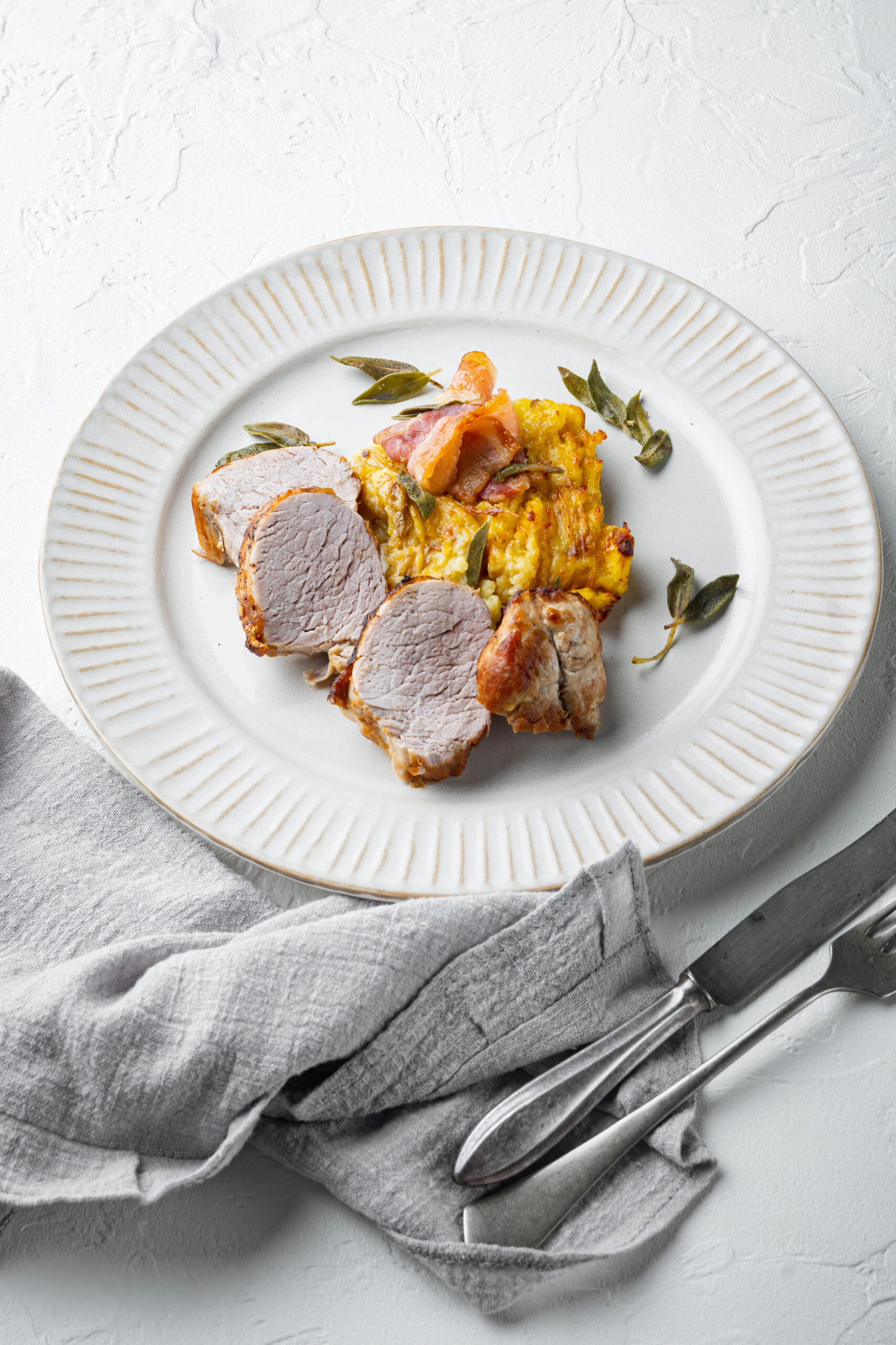 Sliced pork fillet with mashed potato gratin and sage