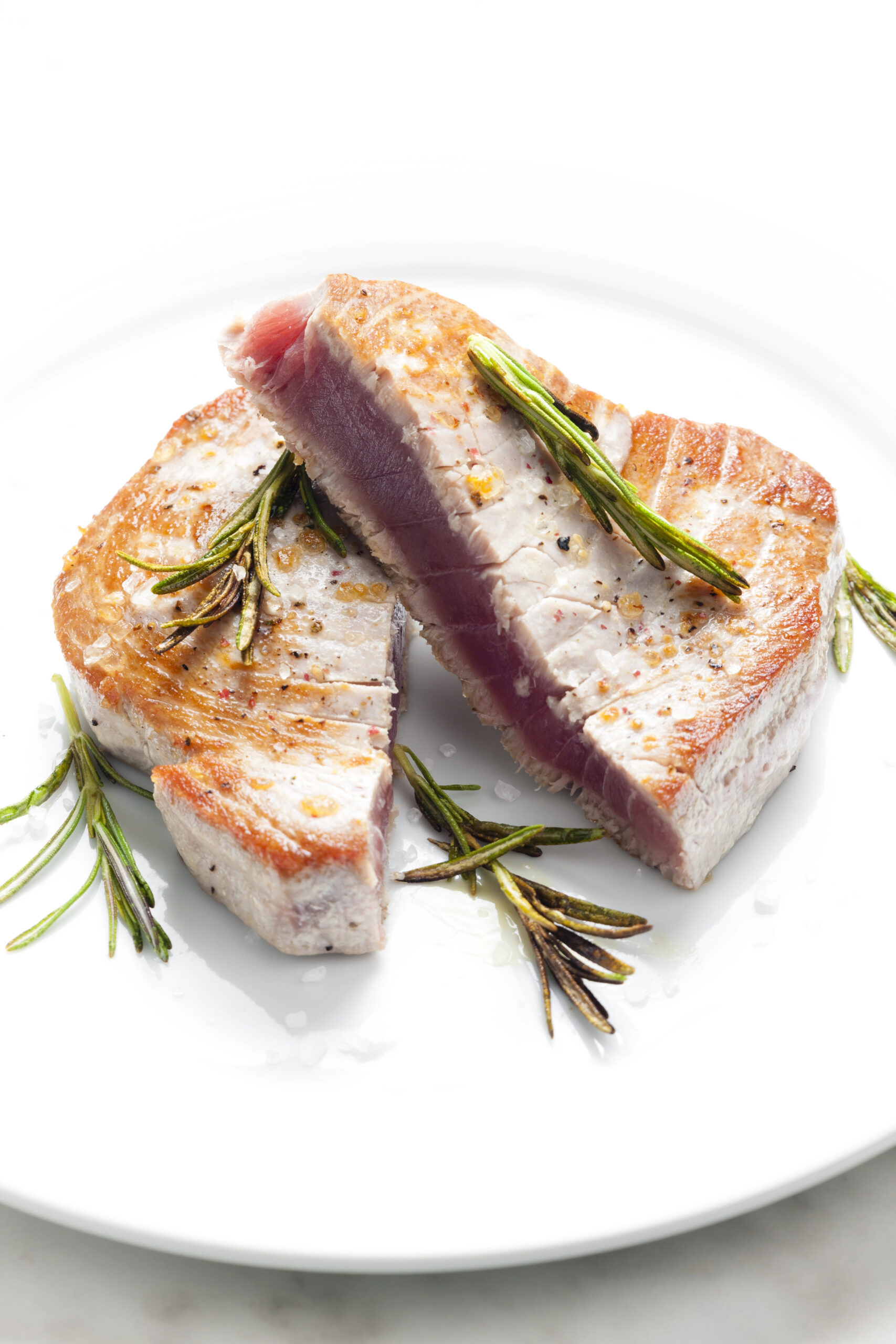 Seared tuna steak with rosemary sprigs