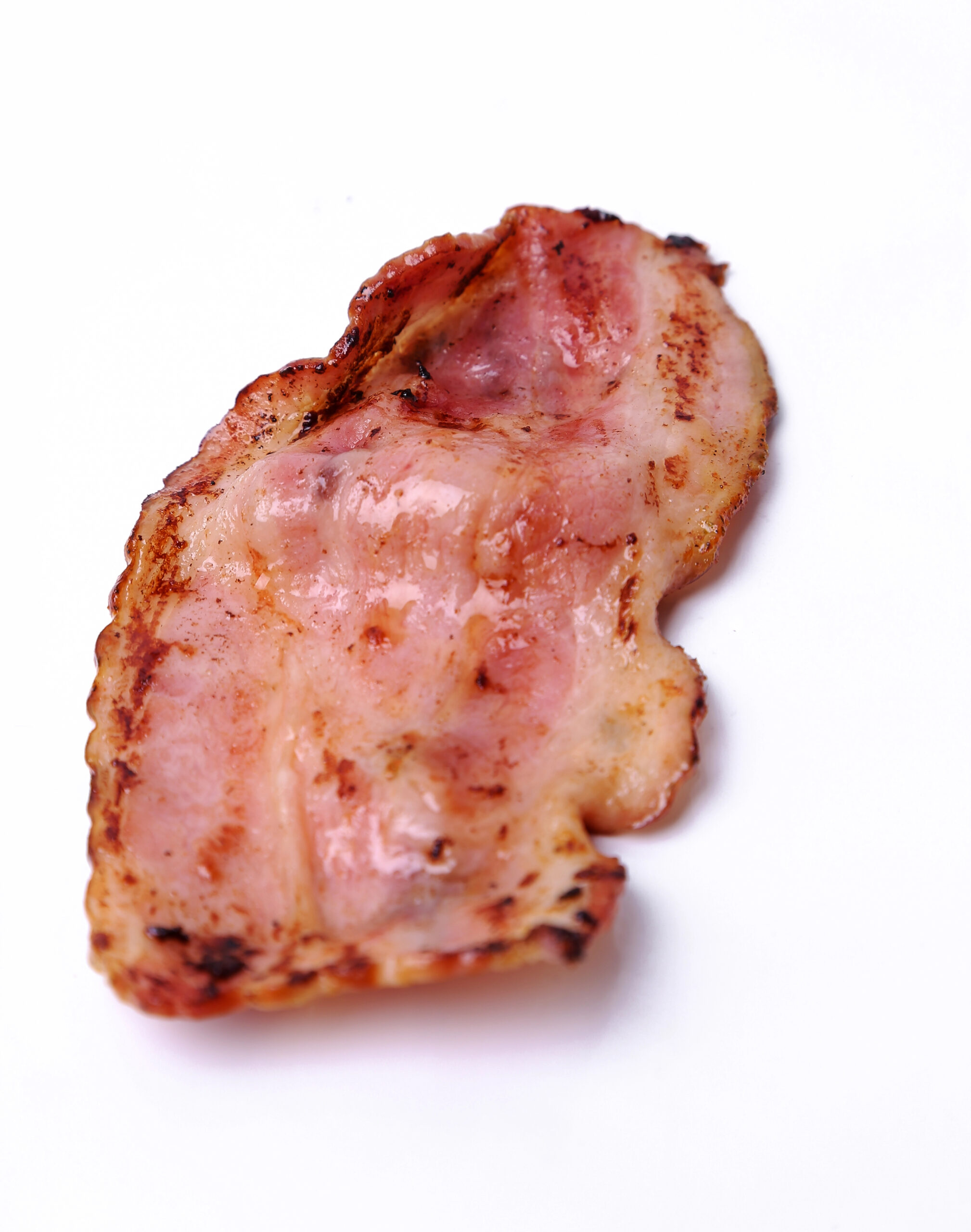 Slice of cooked Canadian bacon with crispy edges