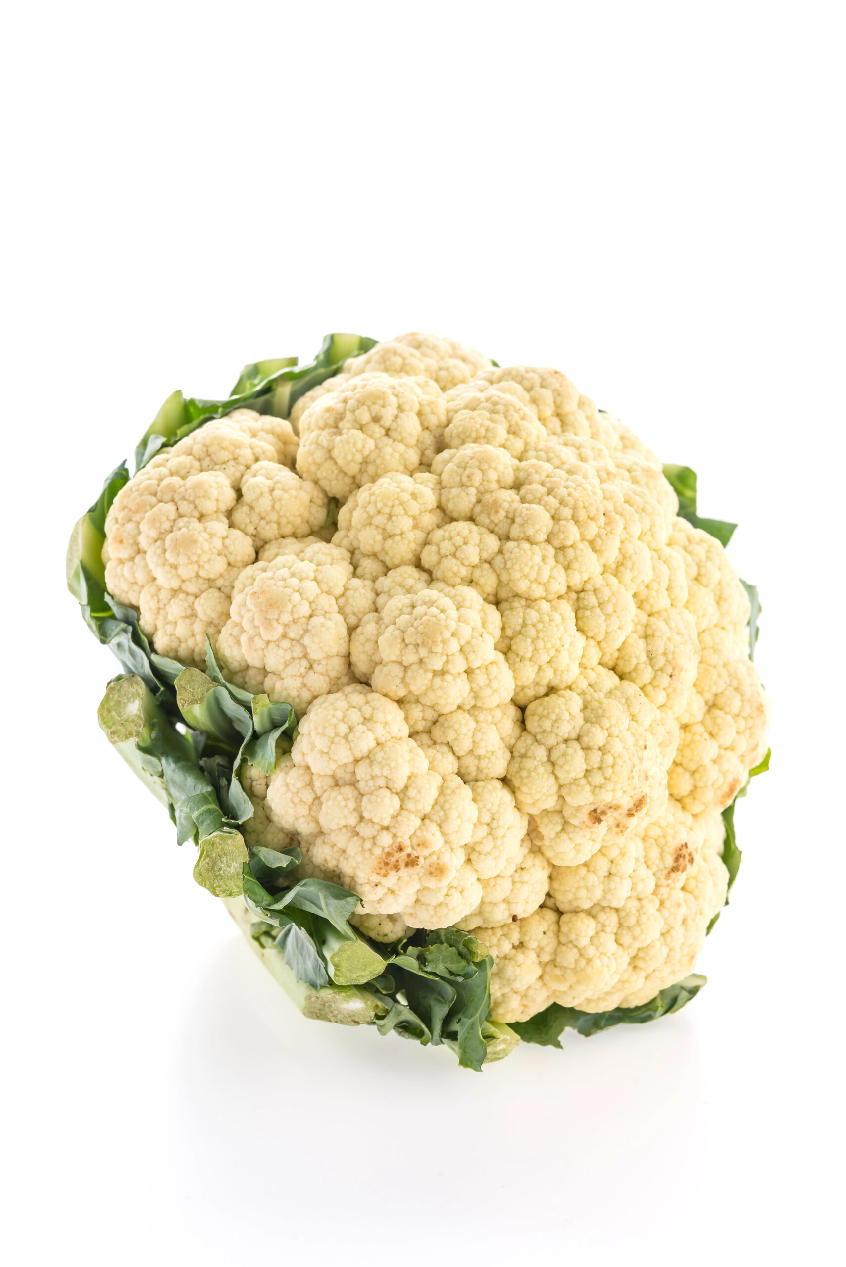 Whole pale cauliflower with green leaves