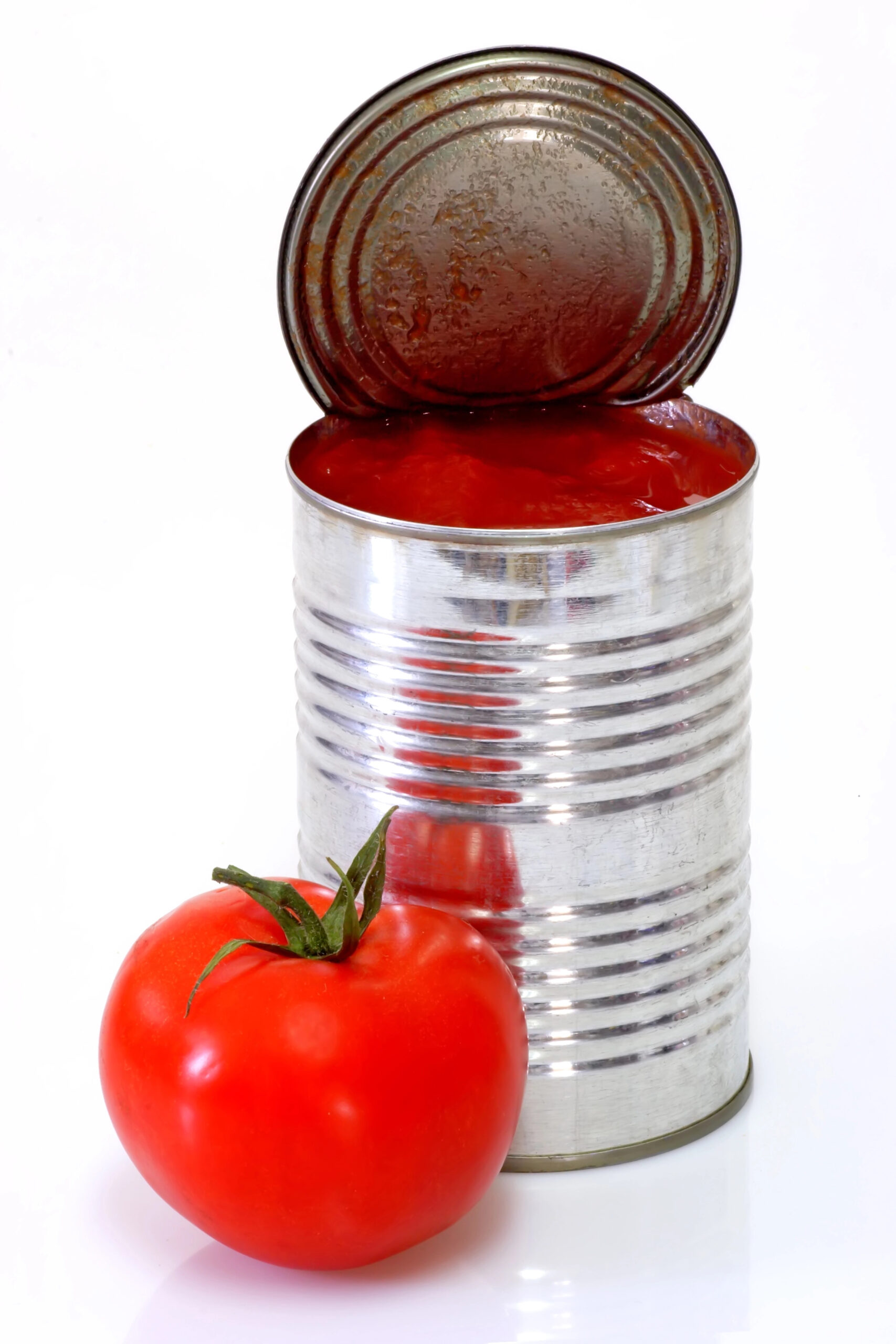 Open can of peeled tomatoes next to fresh tomato