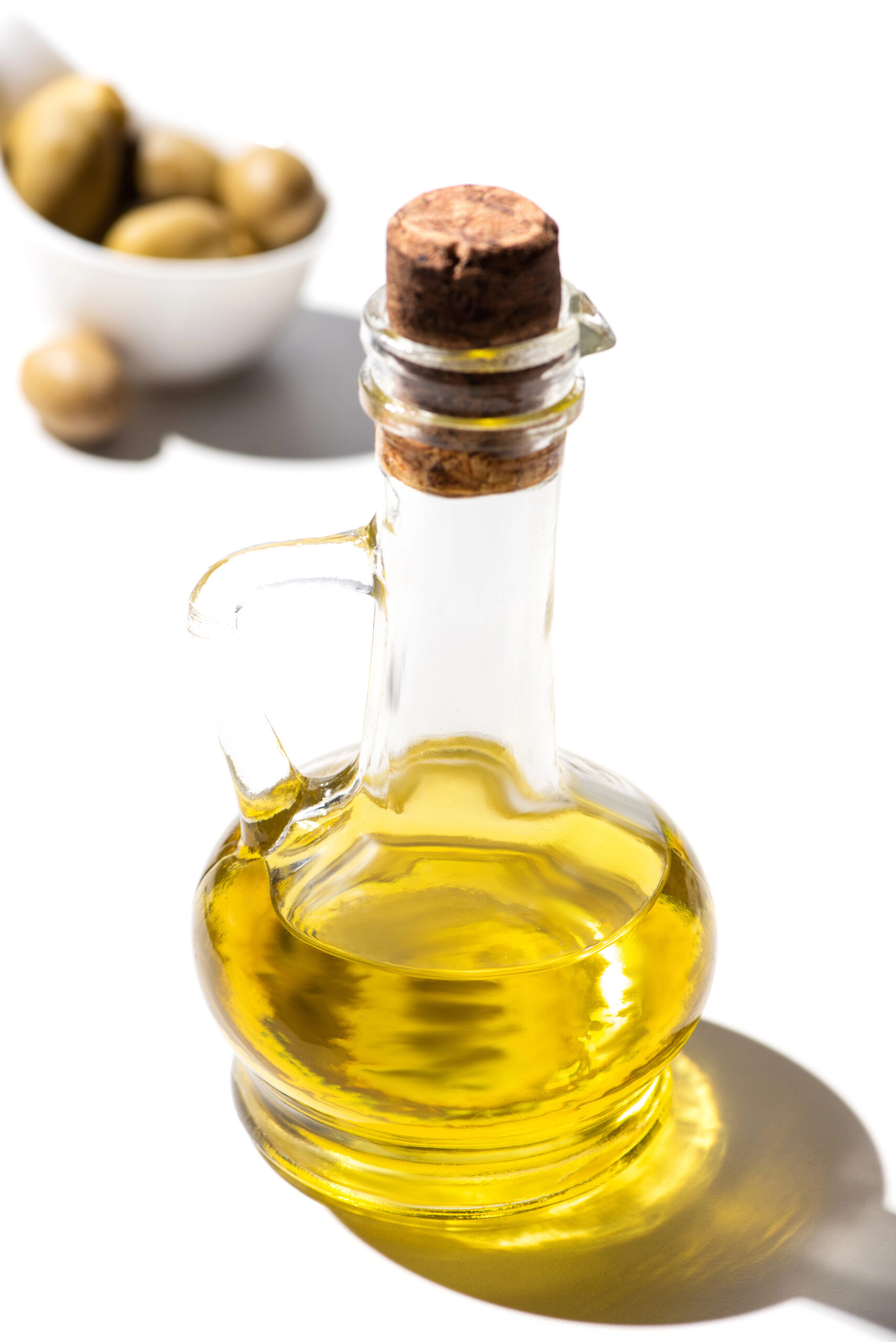Olive oil in clear glass bottle with cork stopper