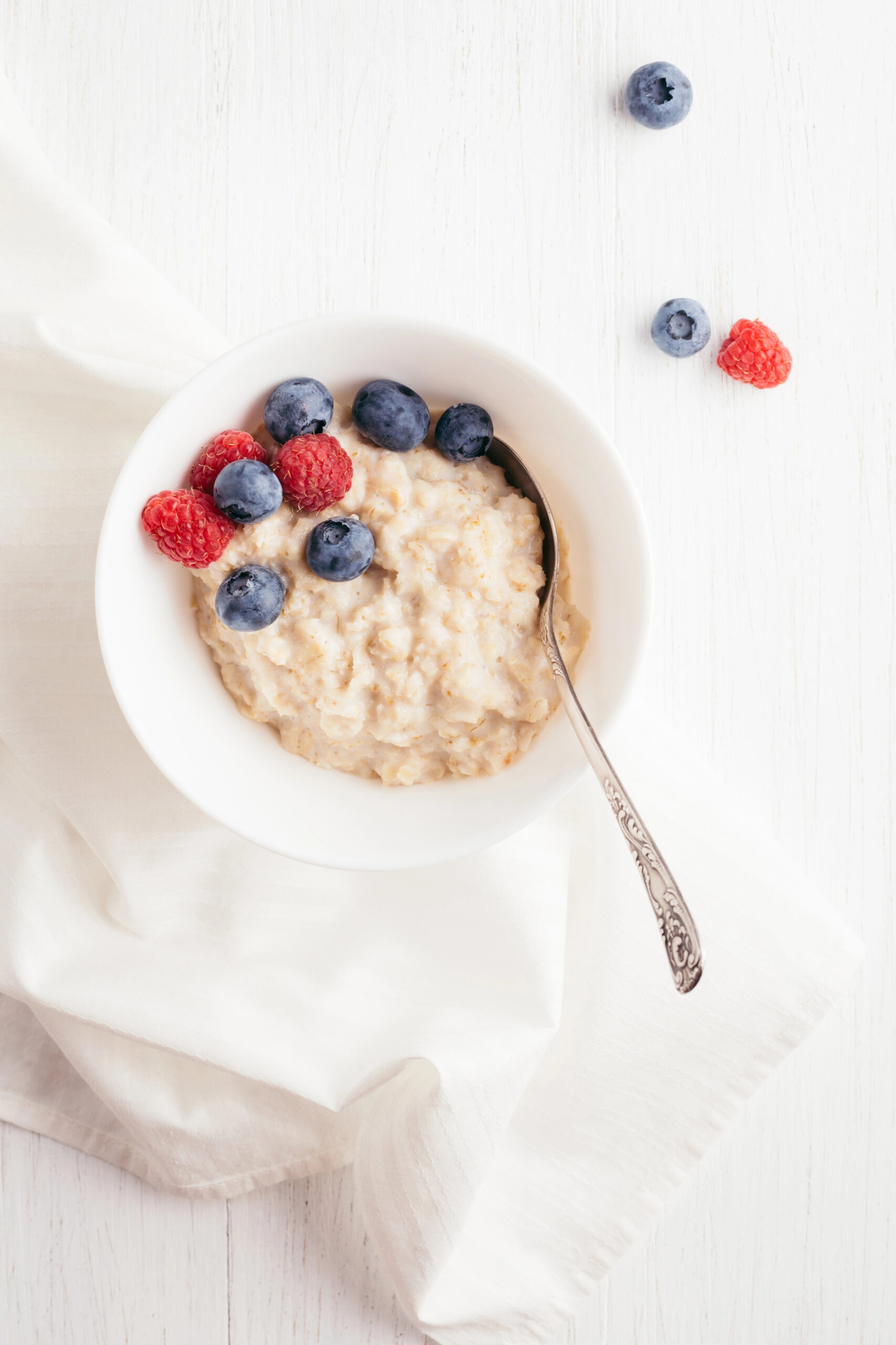 Bowl of oatmeal topped with blueberries and raspberries