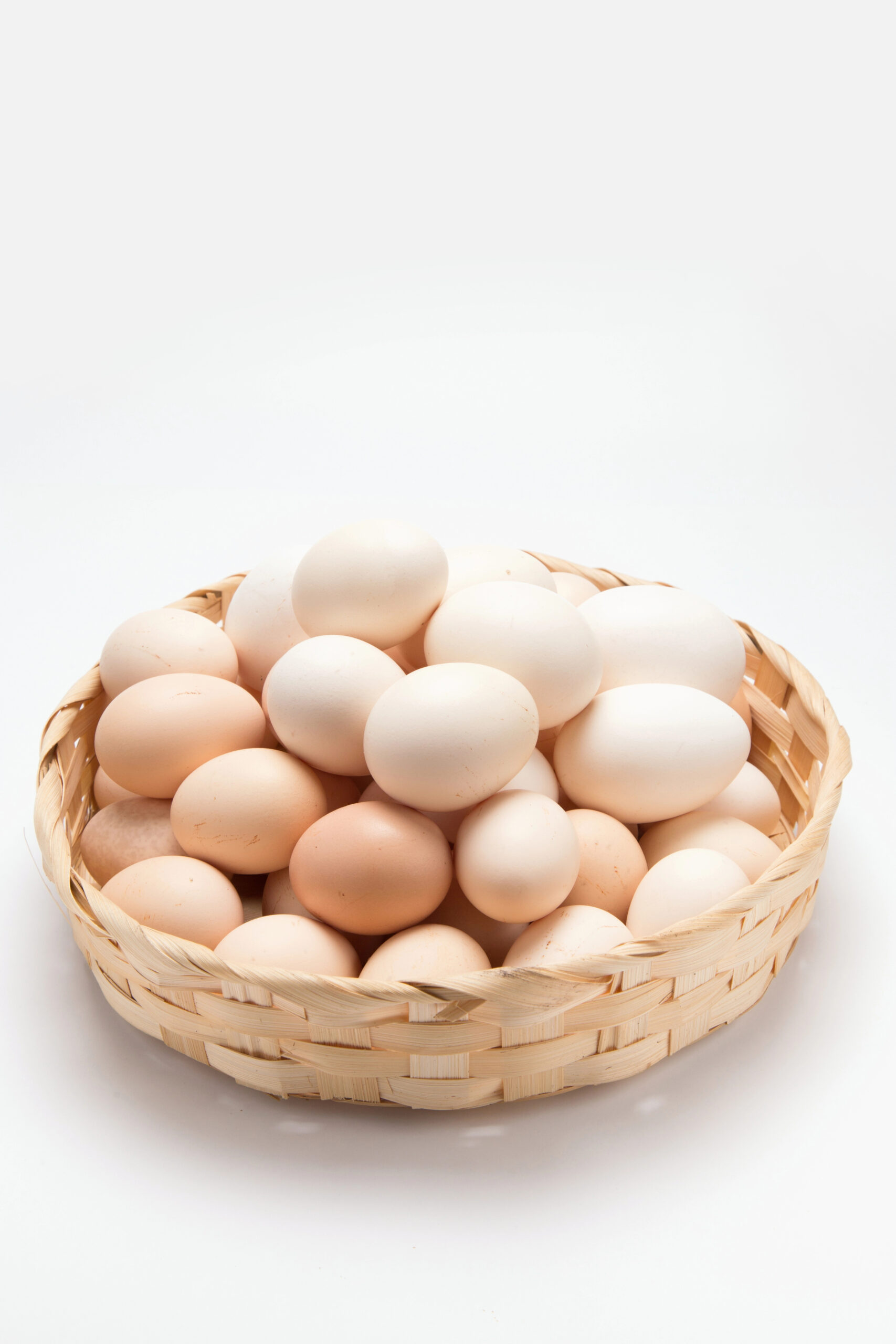 Brown and white eggs in woven basket