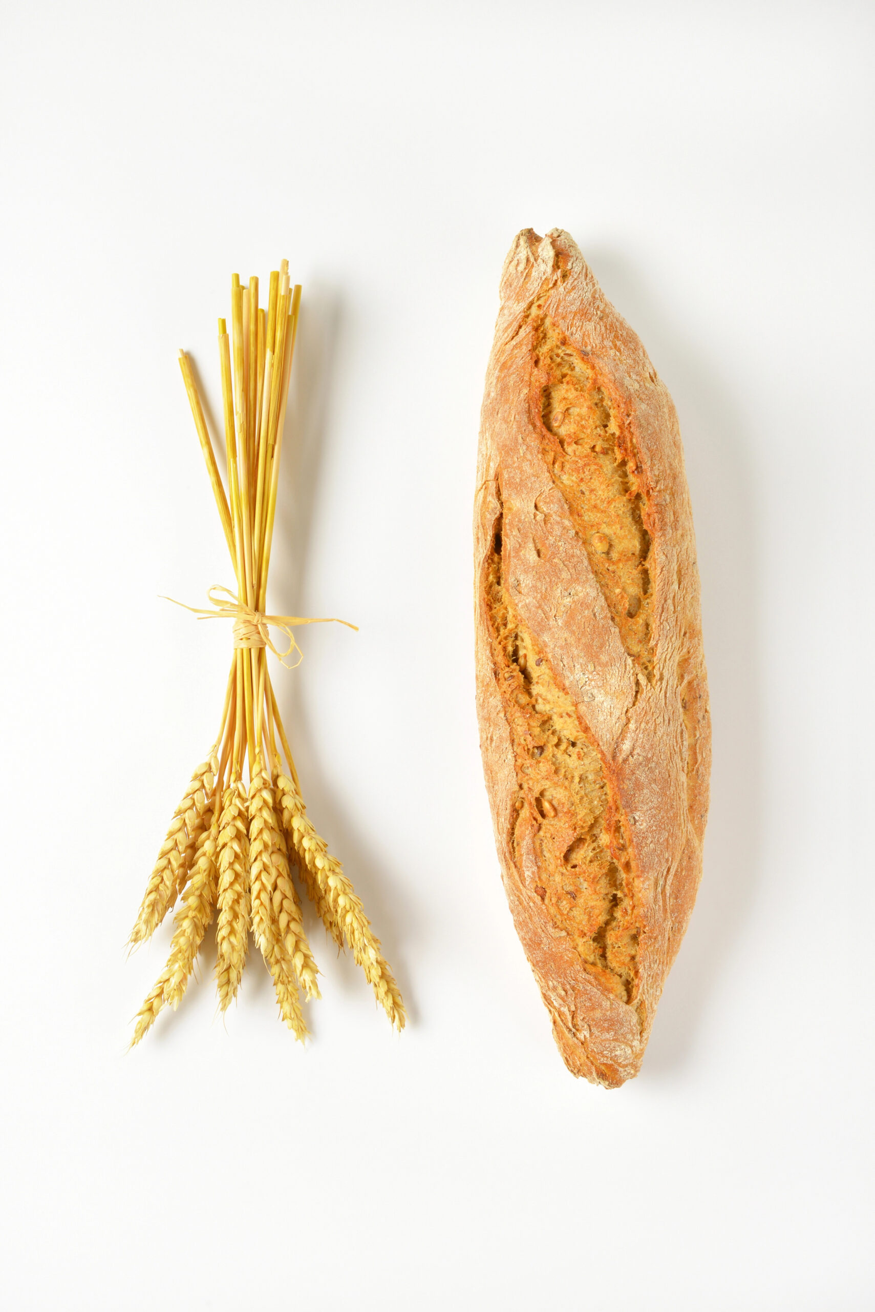 Wheat stalks and whole grain baguette
