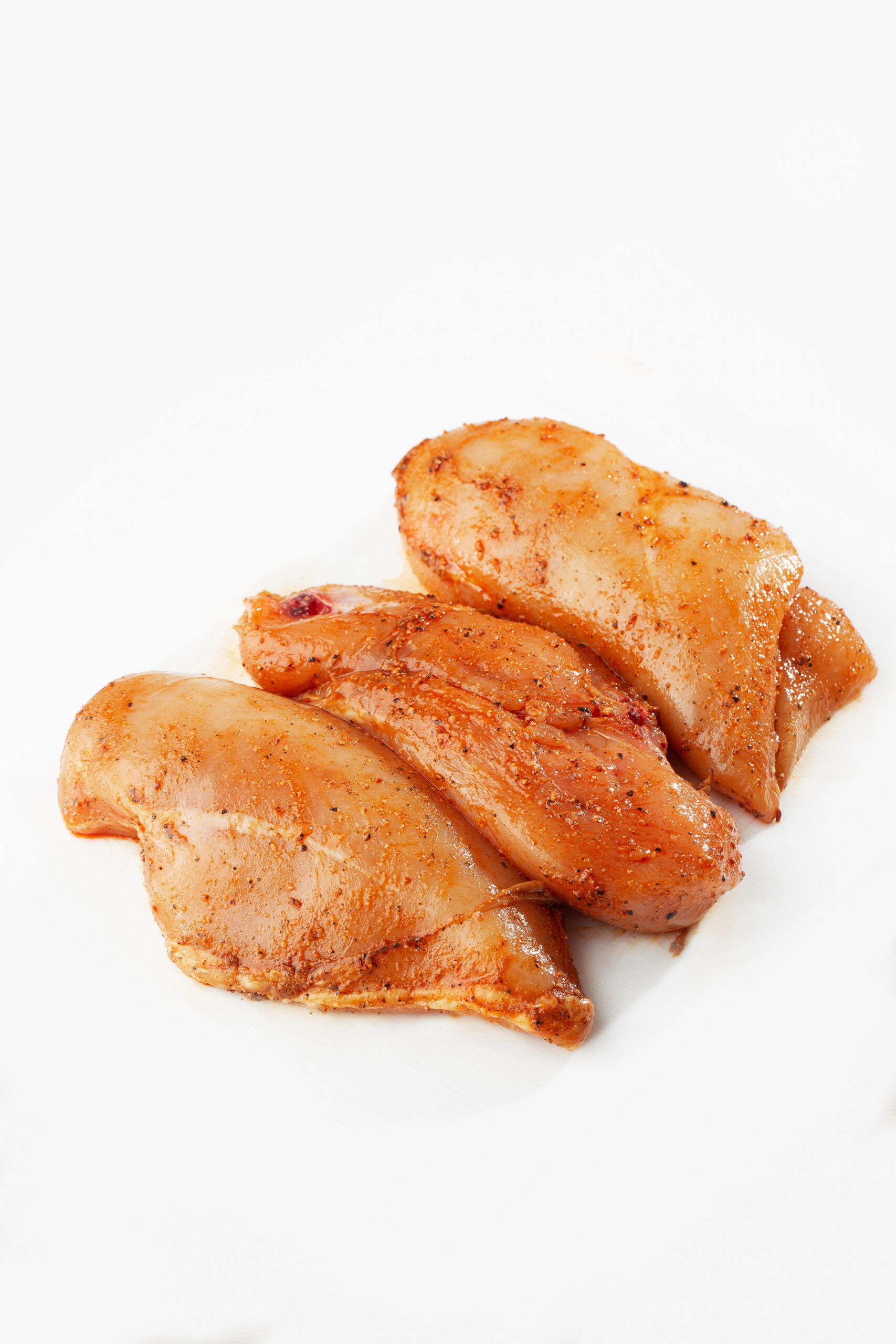 Three raw marinated chicken breast fillets